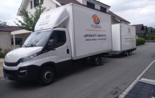 Umzugswagen mit Anhänger Umzugswagen mit Anhänger der PS Umzug AG vor einem Einfamilienhaus